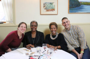 Group of people around a table smiling at the camera